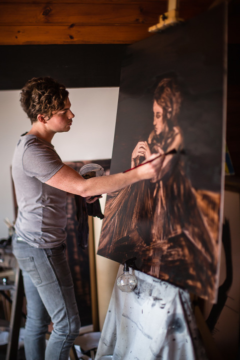 Artist Gerard Russo at work on a painting of a woman on copper