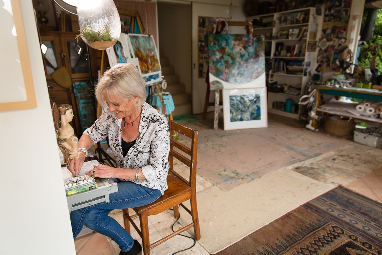 Artist Ches Mills sitting down and working in her studio