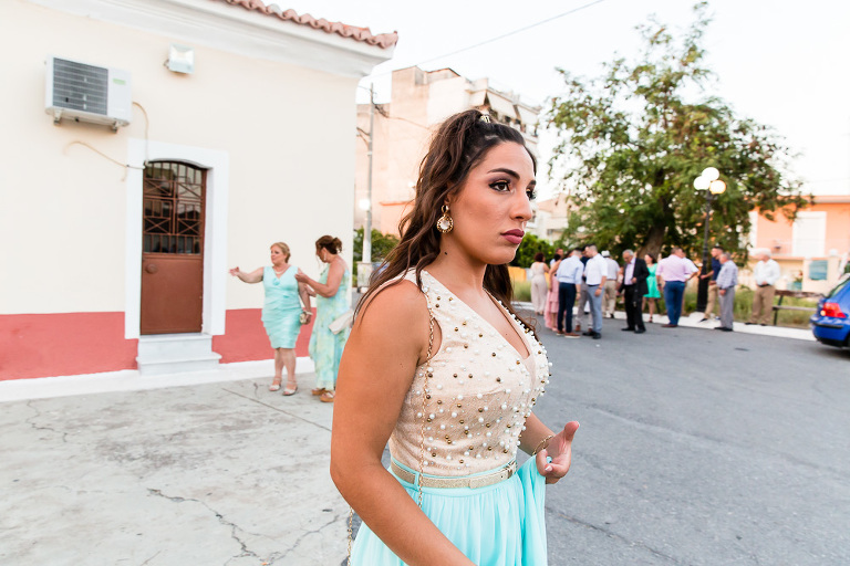 Profile of woman walking past outside with unflattering expression after Greek wedding