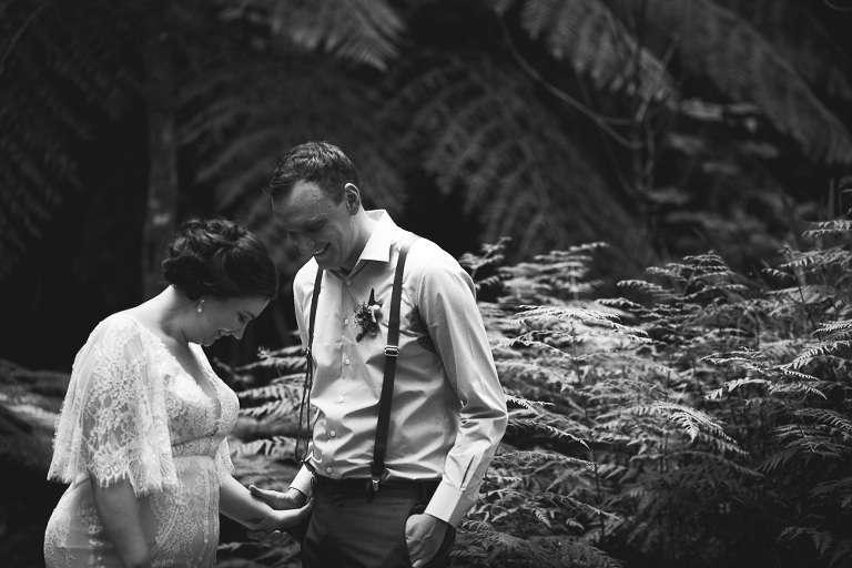 bride and groom showing shy emotions during ceremony amongst ferns