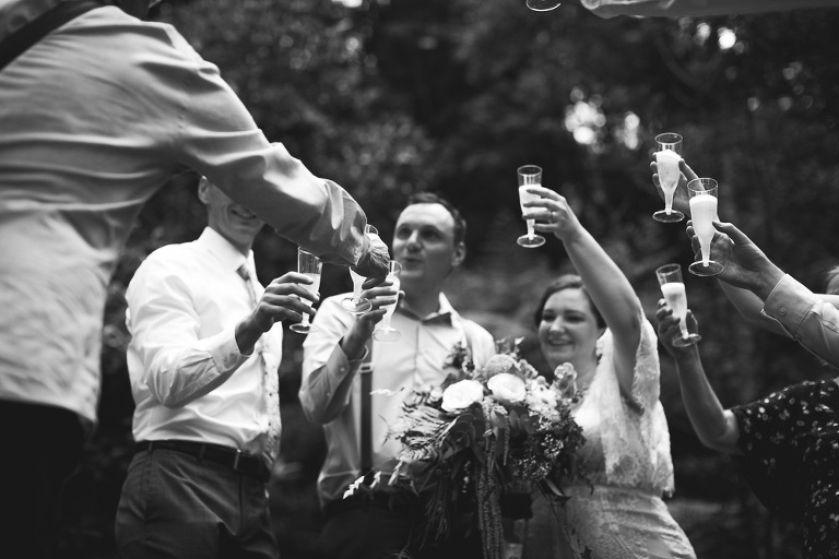 bride and groom toasting with champagne in circle of family