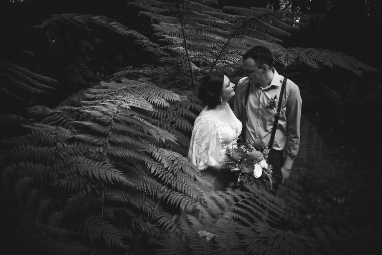 bride and groom looking romantic at each other in ferns